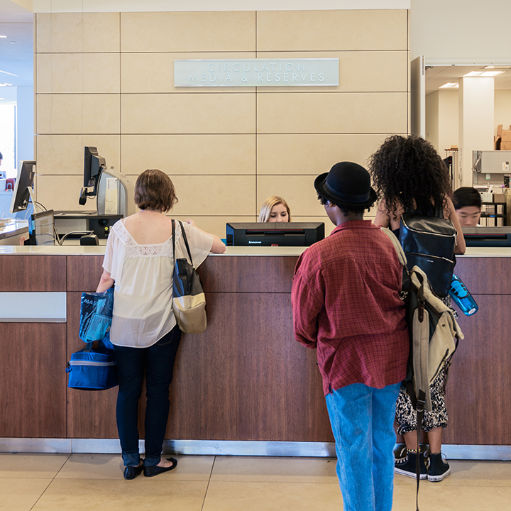 Students standing in line at the library circ desk